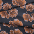 Flores estilizadas en tonos ocre y marrón sobre fondo negro oscuro, diseño artístico botánico decorativo fabric fold mockup
