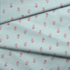 Patrón de rayas verticales turquesa sobre fondo blanco con motivos de hojas rosado coral dispersos fabric fold mockup
