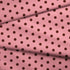 Patrón de pepas café sobre fondo rosado