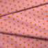 Patrón de pepas naranjas sobre fondo rosado