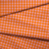 Patrón de cuadros en tonos naranja, rosado y coral vibrantes formando diseño de cuadrícula uniforme