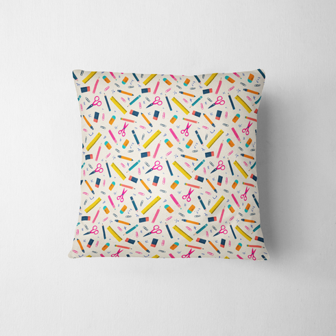Patrón colorido con útiles escolares: lápices, reglas, tijeras y clips sobre fondo crema fabric pillow mockup
