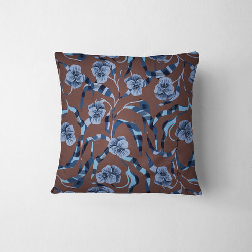 Patrón floral de pensamientos azules sobre fondo marrón con cintas azul y blanco entrecruzadas fabric pillow mockup