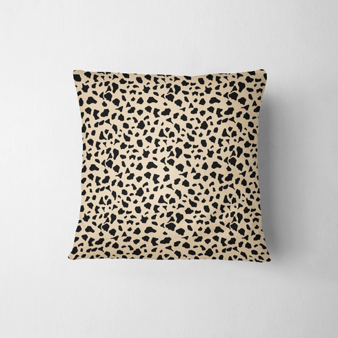 Patrón de pepas irregulares negras sobre fondo beige estilo animal print fabric pillow mockup