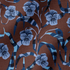 Patrón floral de pensamientos azules sobre fondo marrón con cintas azul y blanco entrecruzadas fabric ripple mockup