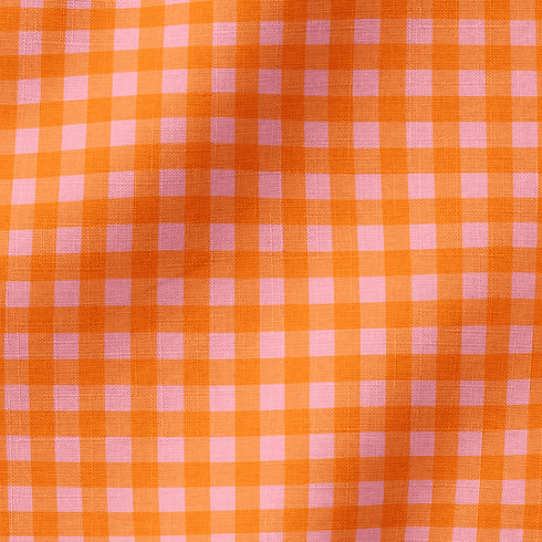 Patrón de cuadros en tonos naranja, rosado y coral vibrantes formando diseño de cuadrícula uniforme