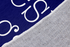 Texto blanco "Nuestro hogar" con flechas decorativas sobre fondo azul marino con marco doble sutex rug 2x3 closeup texture angled