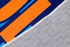 Palabra "HOLA" en naranja sobre fondo de rayas verticales azules y azul marino