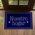 Texto blanco "Nuestro hogar" con flechas decorativas sobre fondo azul marino con marco doble sutex rug 2x3 overhead lifestyle2
