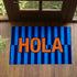 Palabra "HOLA" en naranja sobre fondo de rayas verticales azules y azul marino