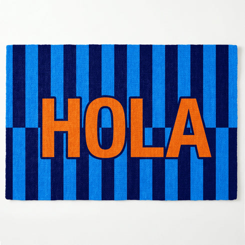 Palabra "HOLA" en naranja sobre fondo de rayas verticales azules y azul marino sutex rug 2x3 overhead white