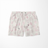 Patrón floral con flores rosado pálido sobre fondo de rayas verticales en tonos crema y beige sutex swimtrunks