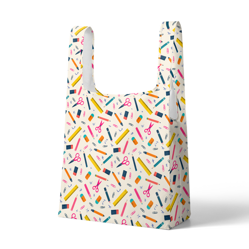 Patrón colorido con útiles escolares: lápices, reglas, tijeras y clips sobre fondo crema sutex tote mockup