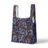 Patrón floral de pensamientos azules sobre fondo marrón con cintas azul y blanco entrecruzadas sutex tote mockup