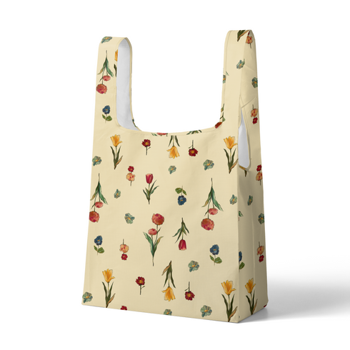 Patrón botánico con flores rojas, azules, amarillas y tulipanes sobre fondo beige claro sutex tote mockup
