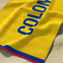 Bandera amarilla con texto azul "COLOMBIA" invertido, bordes rojos laterales sutex towel closeup