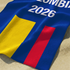 Bandera de Colombia con franjas azul, amarilla y roja sobre fondo azul con texto "COLOMBIA 2026 sutex towel closeup
