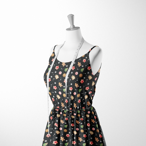 Patrón navideño con galletas decoradas en forma de estrellas, copos de nieve, árbol, casa y muñeco de jengibre sobre fondo negro. sutex woven dress form mockup