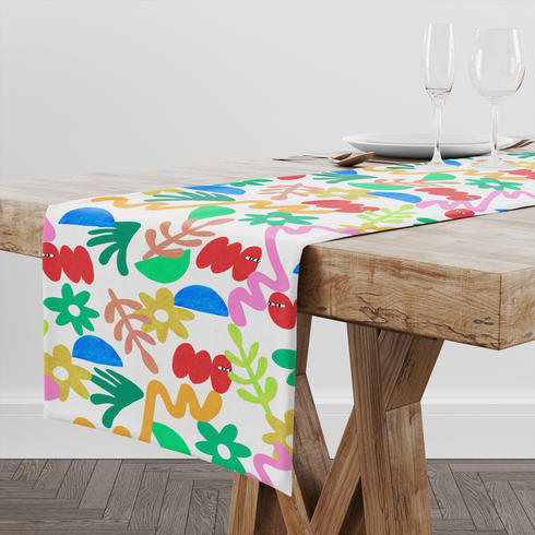 Collage colorido con formas abstractas: flores amarillas, semicírculos azules, líneas onduladas y elementos orgánicos en diversos colores brillantes. table runner mockup