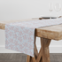 Patrón de rayas verticales azul cielo con delicadas flores rosado pálido dispersas table runner mockup