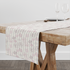 Patrón floral con flores rosado pálido sobre fondo de rayas verticales en tonos crema y beige table runner mockup