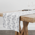 Patrón estampado floral con flores y hojas sobre fondo blanco, diseño botánico delicado table runner mockup