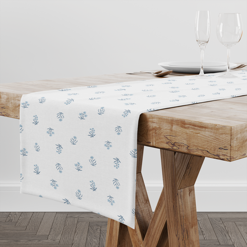 Patrón delicado con pequeñas ramas azules dispersas sobre fondo blanco, estilo botánico minimalista table runner mockup