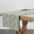 Estampado abstracto con rayas curvas en verde oliva sobre fondo blanco, estilo moderno table runner mockup