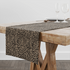 Estampado animal print de leopardo en café y beige sobre fondo negro table runner mockup
