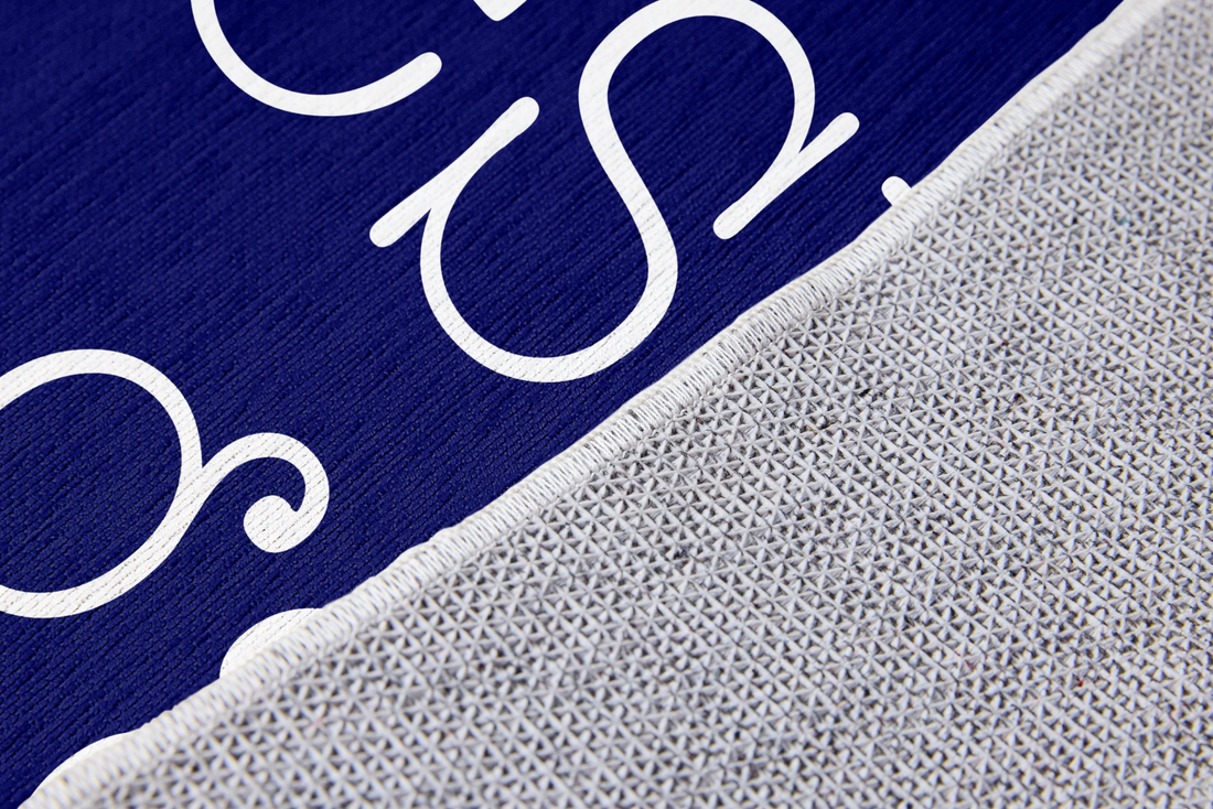 Texto blanco "Nuestro hogar" con flechas decorativas sobre fondo azul marino con marco doble sutex rug 2x3 closeup texture angled
